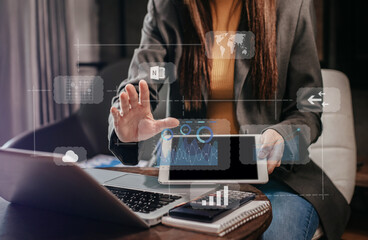 Businesswomen or Designer using tablet with laptop and document on desk in modern office with virtual interface graphic icons network diagram.