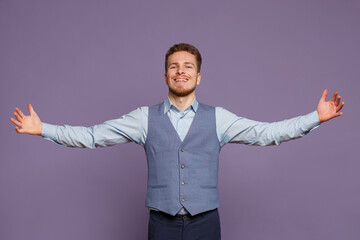 Handsome business man in a suit spreads his arms wide  isolated on a lilac background.