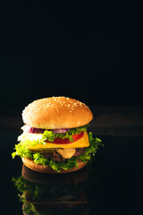 Homemade beef burgers and french fries on dark background.