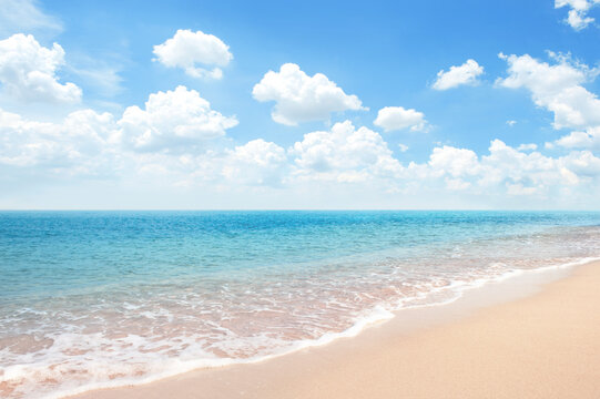 Beautiful Sandy Beach with blue ocean againt blue sky soft cloud , summer background