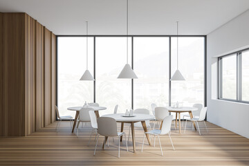 Modern cafe interior with white tables and chairs, panoramic windows