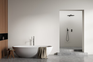 Fototapeta na wymiar Light bathroom interior with bathtub and shower, grey concrete floor. Mockup