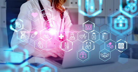 Female doctor wearing white suit is working on laptop