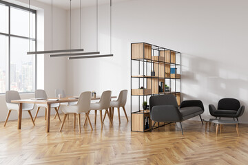 Light meeting room interior with seats, table with laptop, sofa with coffee table