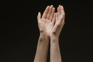 Praying hands to God in the dark. Woman hands reaching out to God or for help in barokko style