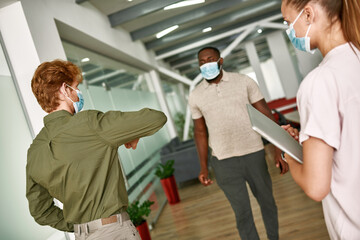 Obraz premium Caucasian man show elbow for hello to black man