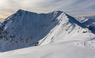 Fototapeta na wymiar Mountain peaks in a beautiful snowy winter scenery.
