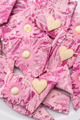 rosafarbene Bruchschokolade mit Blüten und Herzen