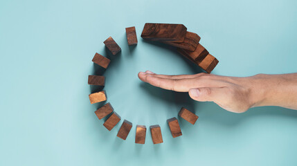 Top view and flat lay design of Businessman use gesture to stop wooden domino circle falling for insurance assurance and risk management concept. - obrazy, fototapety, plakaty