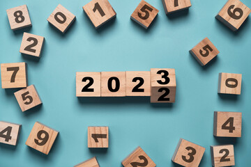 Flipping of 2022 to 2023 on wooden block cube with other number for preparation new year change and...