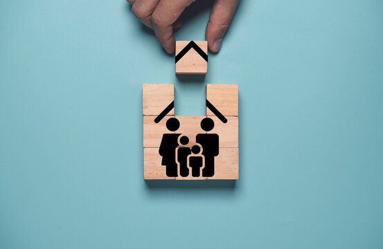 ็Hand holding wooden cube block to complete assemble family insurance icon , Insurance is important for managing risk that may occur in the future both ourselves and our family concept.