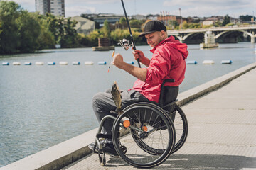 Person with a physical disability who uses wheelchair fishing from fishing pier.