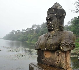 Fototapeta na wymiar Angry Khmer totem and river