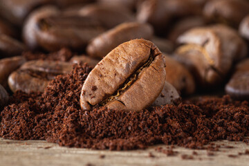 Fototapeta premium Close up of Roasted Coffee bean with ground coffee on wood desk 