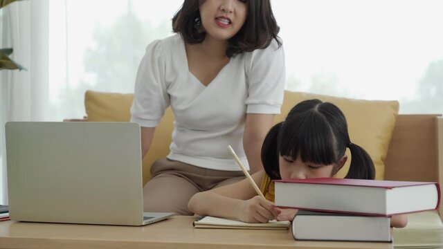 Asian mom and daughter learning online