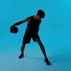 Fototapeta na wymiar Black male player dribbling with basketball ball