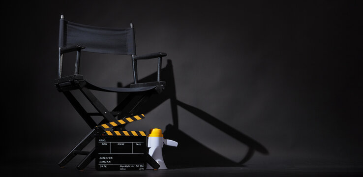Black director chair and Clapper board or movie Clapperboard put on floor with megaphone on black background