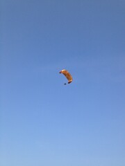 A MINIMAL PHOTO OF A PARAGLIDER PARAGLIDING IN THE BLUE SKY