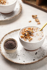 Traditional east european (ukrainian, polish, belarusian) religious christmas dish kutia made of wheat, poppy seeds, honey, walnuts and dried berries. modern style in porcelain bowls, wooden plates