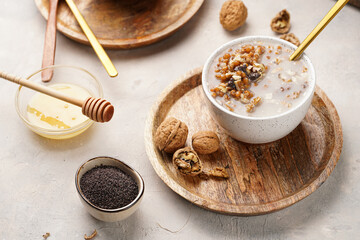 Traditional east european (ukrainian, polish, belarusian) religious christmas dish kutia made of wheat, poppy seeds, honey, walnuts and dried berries. modern style in porcelain bowls, wooden plates