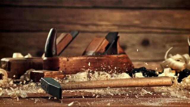 A hammer falls on the table with sawdust. On a wooden background. Filmed is slow motion 1000 frames per second. High quality FullHD footage