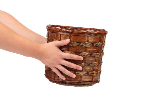 Human hands hold a wicker basket.
