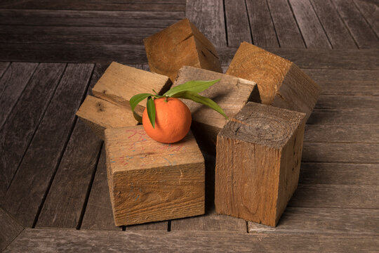 Still life with tangerine and wooden cubes.