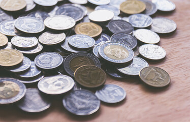 Group of Thai coins on Wooden desk with vintage filter can use as background