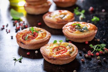 Tasty mini tart with cheese and tomatoes. Vegetarian party food.