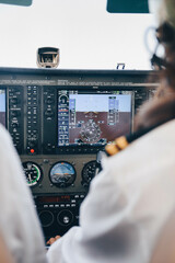Inside view of the cockpit of an unrecognizable female student pilot flying her small plane holding the controls