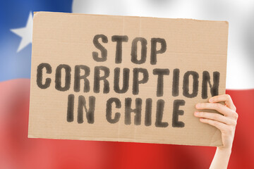 The phrase " Stop Corruption in Chile " on a banner in men's hand with blurred Chilean flag on the background. Forbidden. Prevent. Wealth. Offence. Corruptness. Economy. Corruptible. Political
