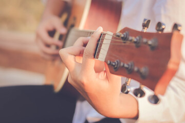 Young man hand playing acoustic guitar.
