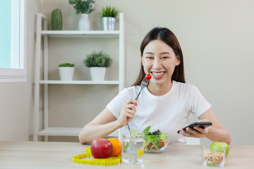 happy females smiling eating salad vegetables fruit and using smartphone, diet day weight counting calories. eating and health care concept.