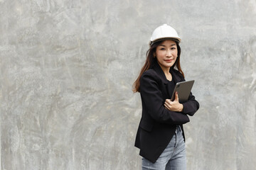 successful asian women engineering wear black suit holding tablet working in construction site. woman freelancer lifestyle human urban. copy space use for text word.