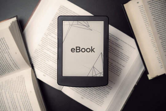 E reader. Digital e book, library reader tablet with books on dark background. Online education course, E learning class and ebook digital technology concept.