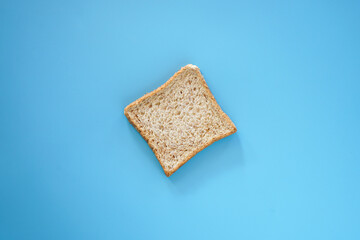 Single whole wheat bread on blue background