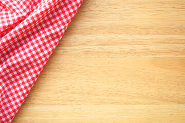 Crumple pink plaid fabric or tablecloth at the corner of wood desk with copy space