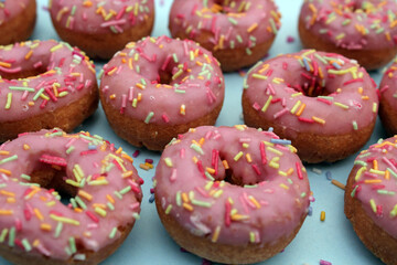 donut donuts sprinkles on doughnuts pink bright sugar strands background 100s and thousands decoration on turquoise blue repeat pattern background flat lay 