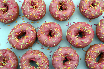 donut donuts sprinkles on doughnuts pink bright sugar strands background 100s and thousands decoration on turquoise blue cyan repeat pattern background flat lay 