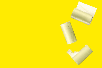 Yellow background with falling toilet paper rolls and empty space for text. A backdrop on the topic of ecology and waste recycling during the global crisis and the lack of basic materials.