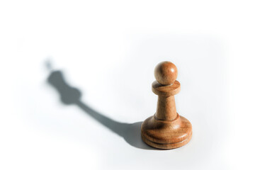 chess pawn with shadow of chess queen isolated on white background.