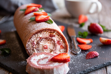Delicious strawberry roll cake with white cream, homemade baked dessert