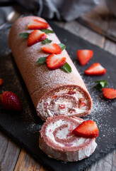 Delicious strawberry roll cake with white cream, homemade baked dessert
