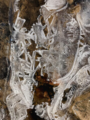 Frozen water lies on the river covered with rime ice in the early morning in winter season. Abstract natural textured background.
