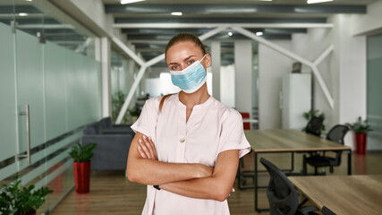 Young woman in medical mask looking at camera