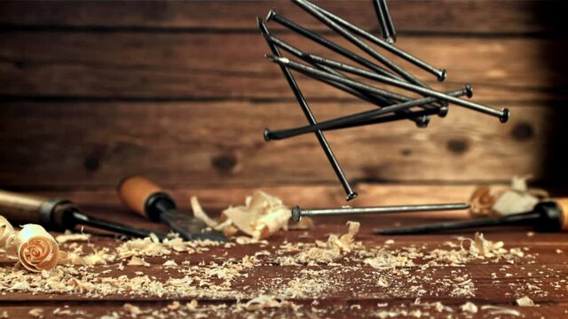 A lot of nails fall on the table. On a wooden background. Filmed is slow motion 1000 frames per second.High quality FullHD footage