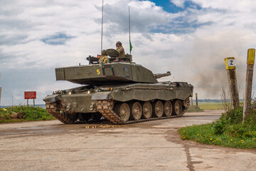 close up of commander and gunner atop a british army challenger 2 main battle tank in action on...
