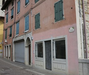 Fototapeta na wymiar Cividale del Friuli Street View with Pink Bulding Facades and Green Shutters, Italy