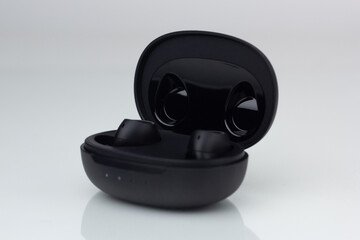 Closeup of isolated wireless Bluetooth headphones in a case.