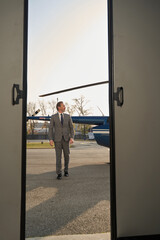 Businessperson walking across helipad and looking away